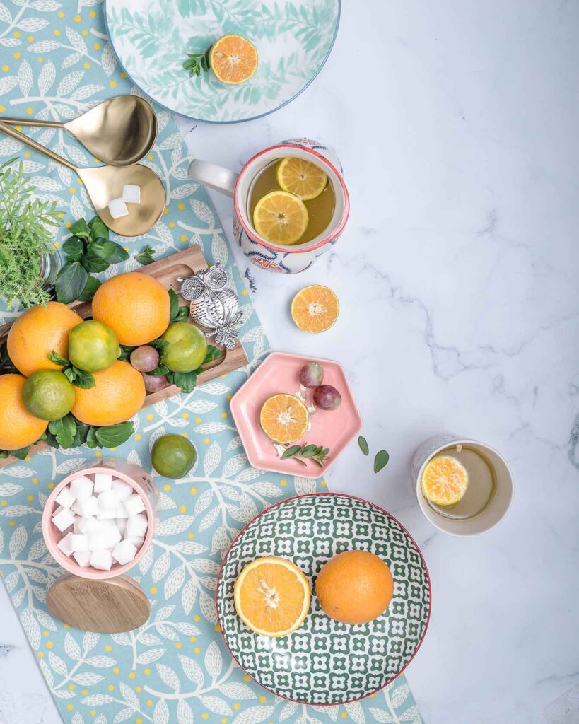 Orange juice with citrus fruits placed in one side of frame and other half is left as negative space