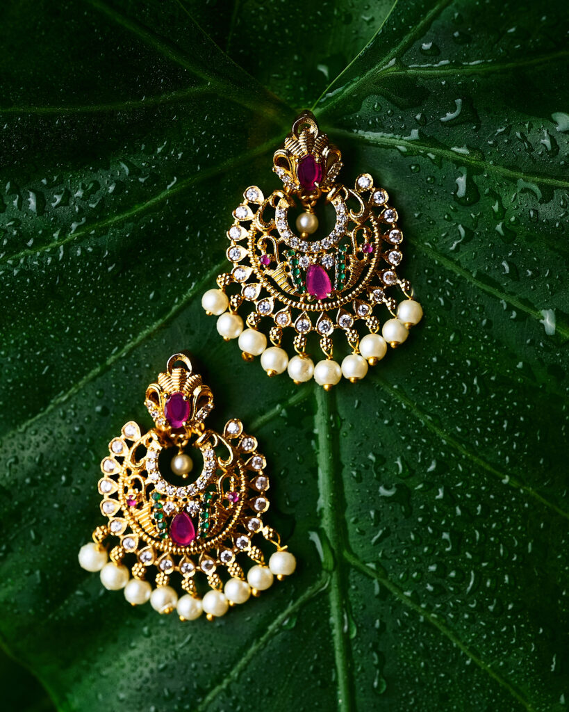 moody photo of ear rings arranged in a leaf with water droplets