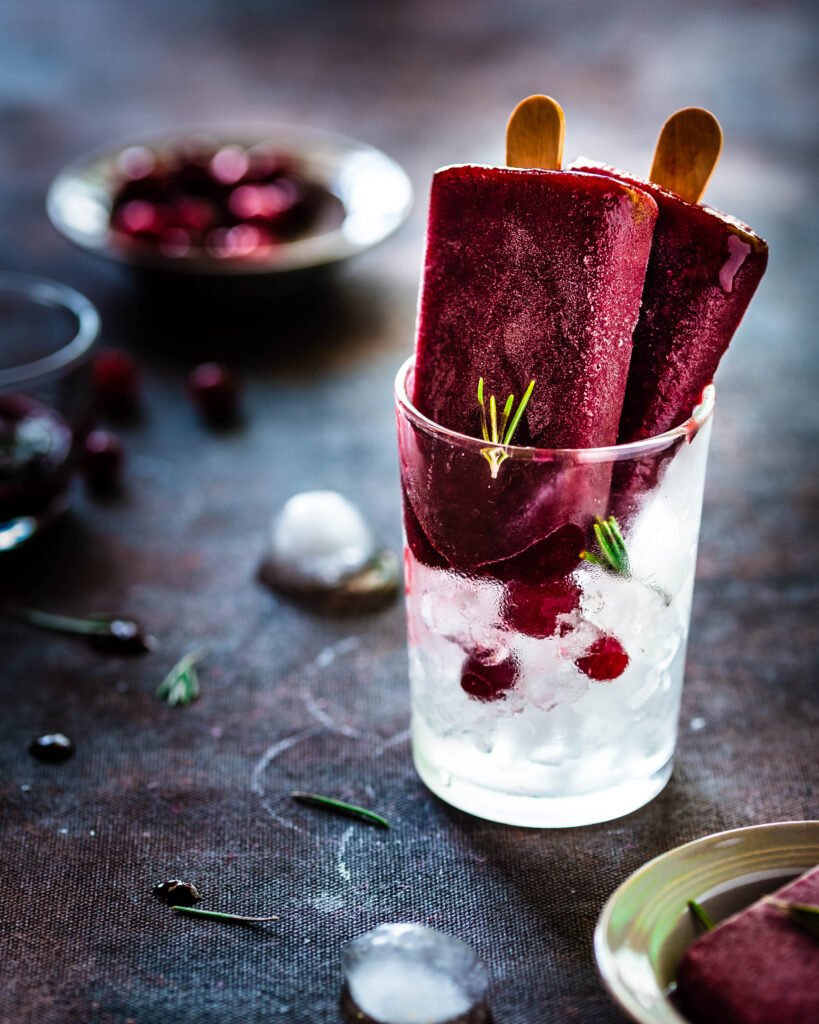 Berry popsicle placed against a dark moody setup with a touch of editorial style photoshoot